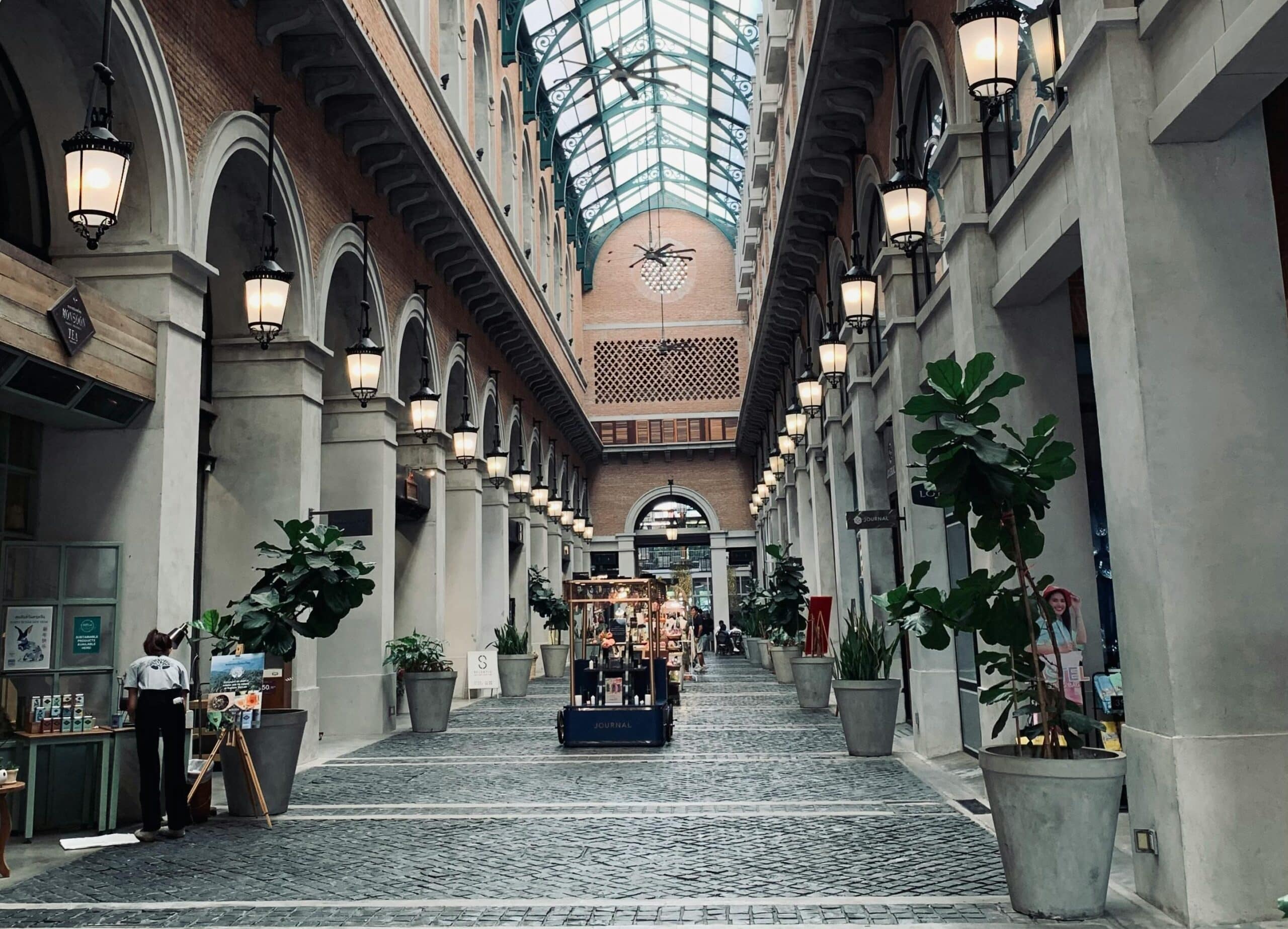 Elegant indoor shopping arcade with plants.