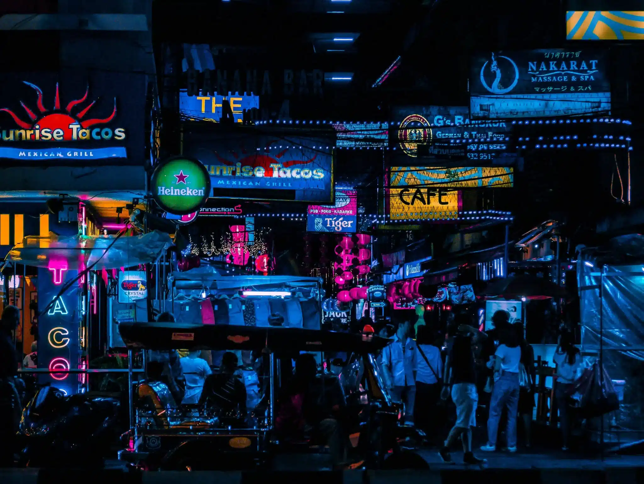 Silom street in bangkok, neon lights with people walking about